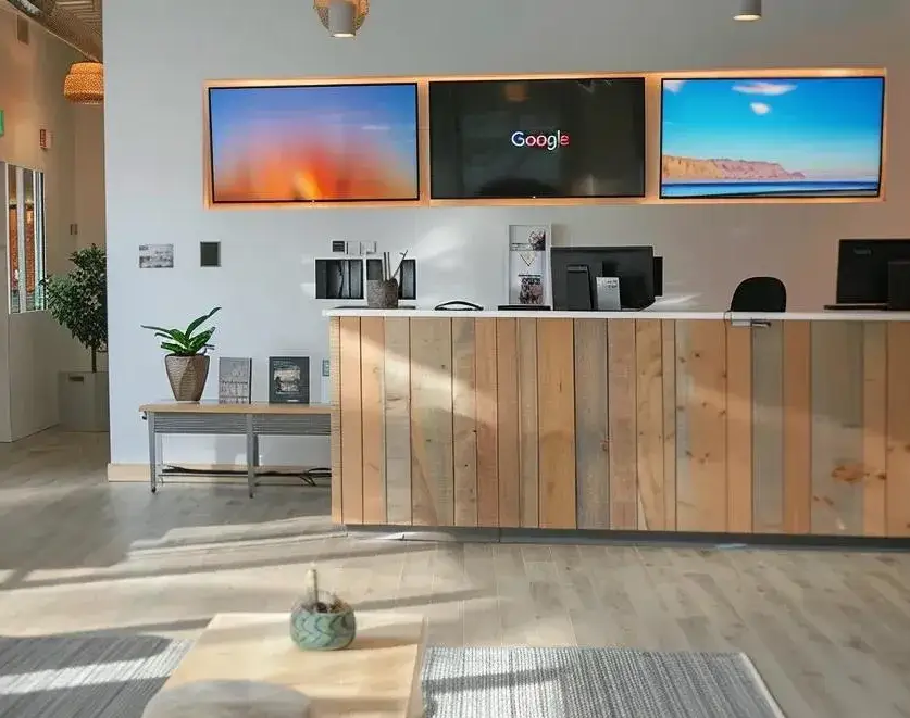 Office reception area with wall screens showing a Google search page