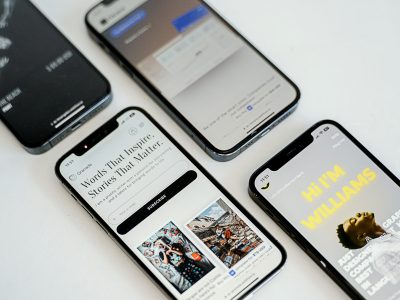 Four smartphones displaying various mobile-friendly website designs, illustrating responsive web design principles relevant to enhancing user experience and engagement for local businesses.