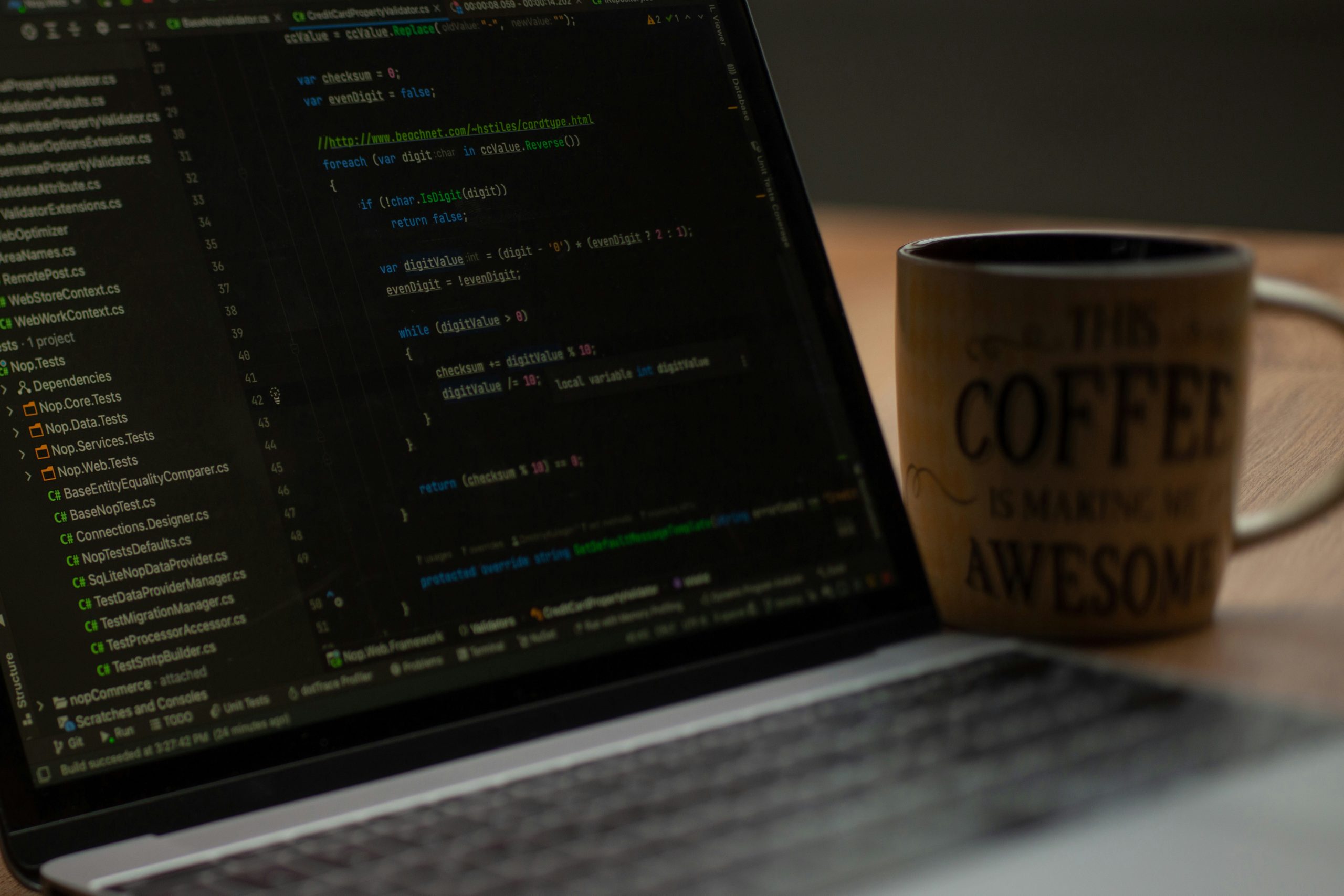 Laptop displaying code for web development alongside a coffee mug with the phrase "THIS COFFEE IS MAKING ME AWESOME", reflecting a professional web design environment.
